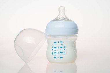 Beyaz arka planda bir şişe süt.