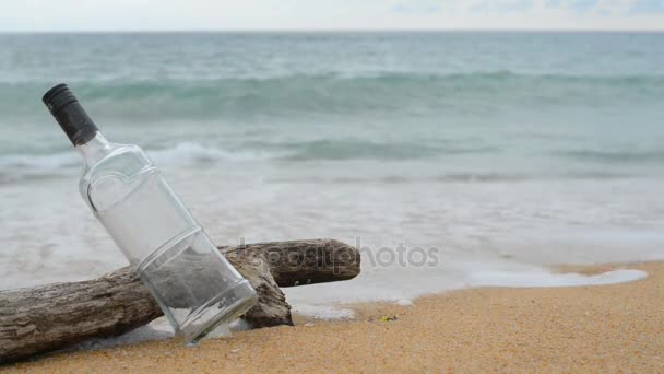 Glazen fles op het strand. — Stockvideo