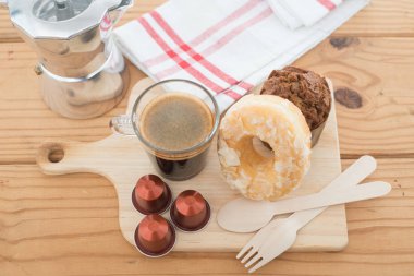 Fincan espresso ve ahşap masa üzerinde ekmek ile espresso kapsül.