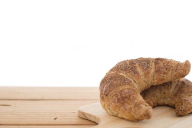 Kruvasan beyaz arka plan ile ahşap tablo.