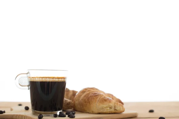 Tasse Espresso und Croissant auf Holztisch. — Stockfoto
