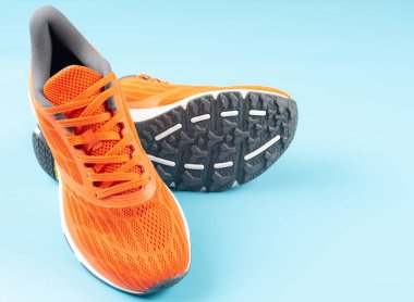 Mavi arka planda turuncu spor ayakkabılar. Sağlıklı yaşam kavramı