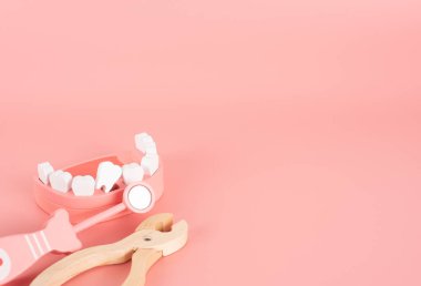 Tahta oyuncak, yaşlılar, kalp hastalıkları, yüksek tansiyon, diyabet, kanser, çocuklarda Covid-19 hastalıkları, genel insan hastalıkları ve sağlıklı yaşam konseptinde pembe arka planda yatar..