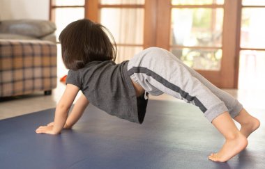 Asyalı kızlar ve anneler yoga yaparken internetteki yoga videolarını izliyor ve takip ediyorlar. Boş zamanlarını evde geçirdikleri tatillerde, Covid-19 salgını sırasında faydalanmak için kullanıyorlar..