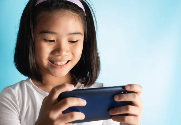 Asian children are holding mobile phones by searching for knowledge from online media there are many on the internet to improve knowledge. Ability in various fields Including for fun and entertainment In today\'s world.