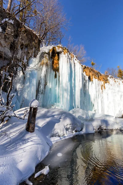 Cascata ghiacciata e riflessione sull'acqua nei laghi di Plitvice, Croazia — Foto Stock