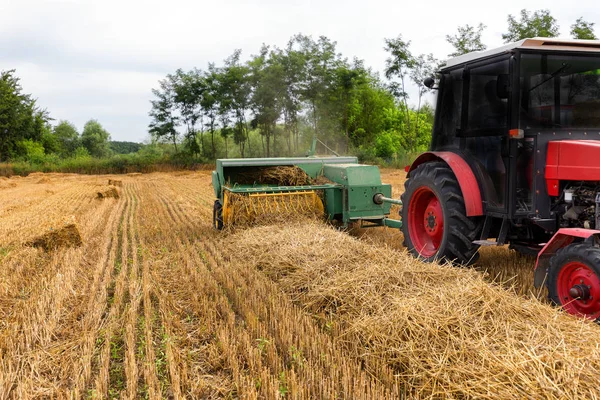 Trattore fare balle di paglia. Concetto agricolo — Foto Stock