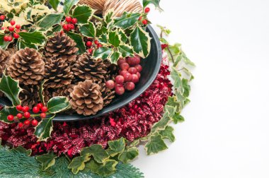 Holly ve beyaz arka plan ve kırmızı kurdele üssünde Ivy ile şenlikli Noel dekorasyon