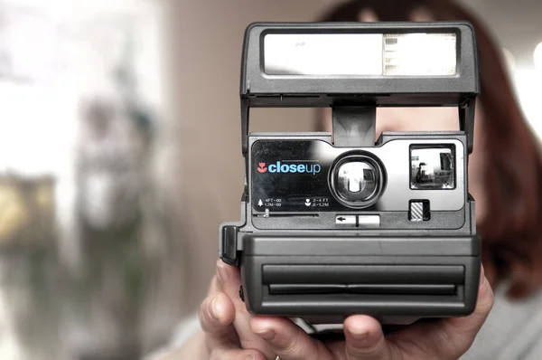 Girl taking a photograph with an instant camera