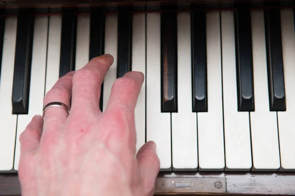 Mano masculina tocando una canción en el piano — Foto de Stock