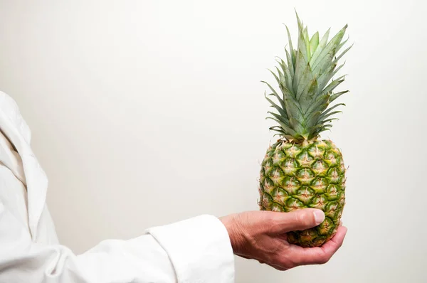 Un hombre sostiene una piña fresca con espacio de copia para el texto — Foto de Stock