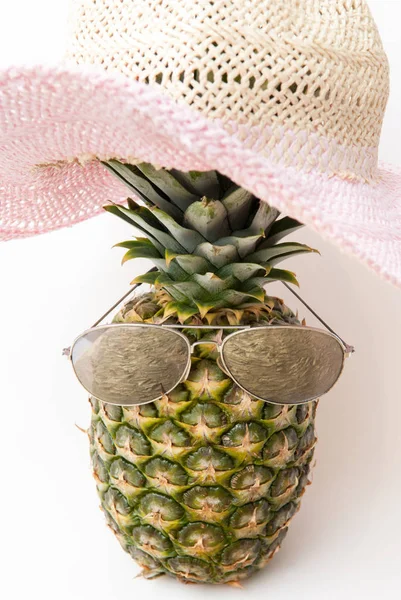 Забавный ананас в тенях и шляпе от летнего солнца — стоковое фото