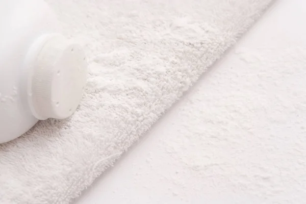 Talco en polvo sobre un fondo de toalla blanca suave — Foto de Stock