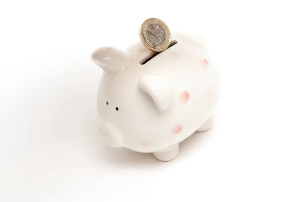 Piggy bank with coin being placed in for savings — Stock Photo, Image