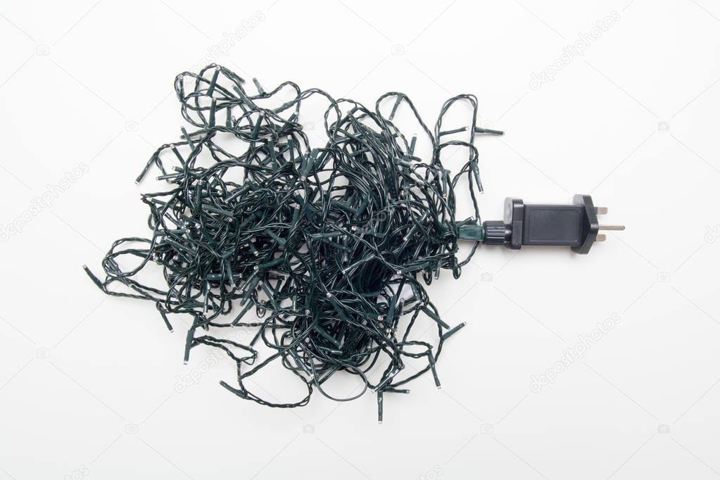 Tangled christmas tree lights with knotted wires and cable