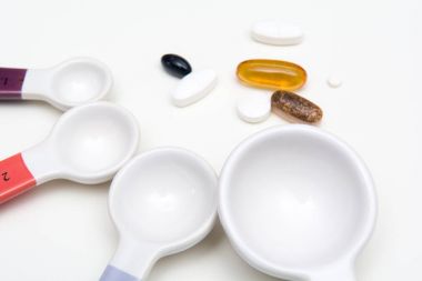 Tıp hapları ve tablet ilaç doz ölçmek için kaşık ile.