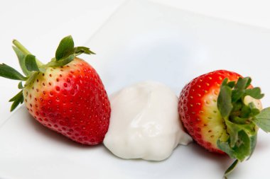 Taze olgun çilek ve krema beyaz Masa arkasında izole