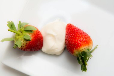 Taze olgun çilek ve krema beyaz Masa arkasında izole