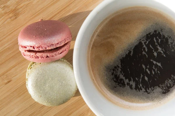 Café et macarons sur table en bois au soleil — Photo