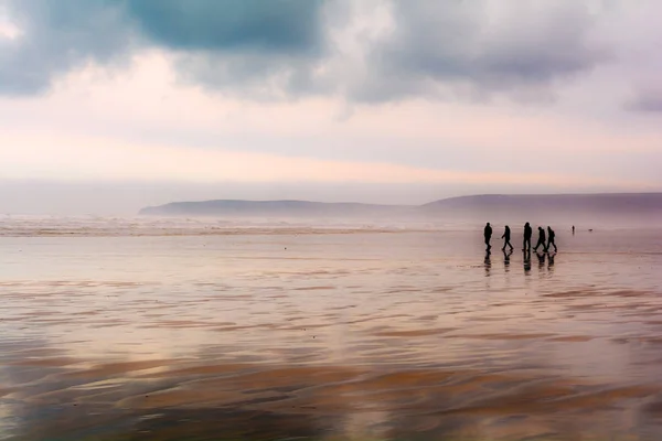 Gruppe von Menschen an einem Sandstrand bei nassem Wetter — Stockfoto