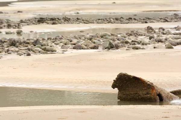 Sandy UK praia na maré baixa com piscinas de rocha — Fotografia de Stock
