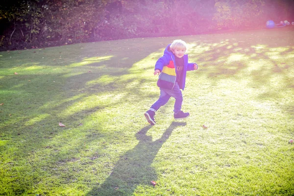Criança brincando fora em um jardim durante o dia com bolhas h — Fotografia de Stock