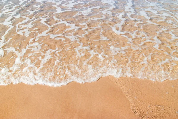 Aguas poco profundas en la orilla mientras olas suaves rompen sobre el cálido yello —  Fotos de Stock