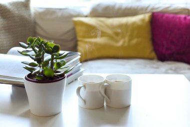 Modern evdeki kahve masası ve sıcak içeceklerle dinlenme yeri.