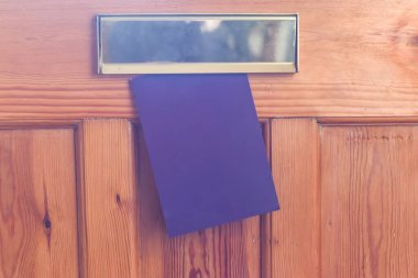 Blank leaflet or flyer being posted through a letter box unwante
