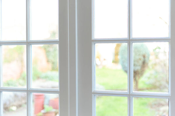 Стильный интерьер комнаты с французскими дверями и светло-нейтральным цветом
