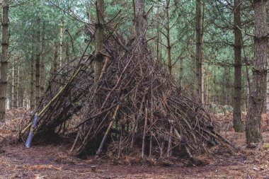 Ormana bir barınak yapın. Dışarıda oynayan çocuklar tarafından yapılmış bir çadır kulübesi ya da mağara.