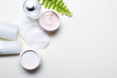 Yüz temizleme ürünleri ve yüz kremi ve pamuk yastıklı kaplar.