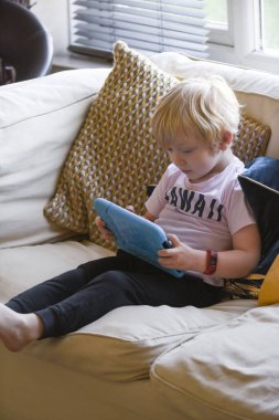 Evde öğrenme uygulaması olan bir tablet aygıtı kullanan bir çocuk