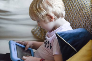 Evde öğrenme uygulaması olan bir tablet aygıtı kullanan bir çocuk