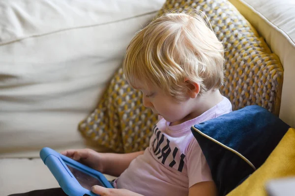 Boy using a tablet device with learning app at home