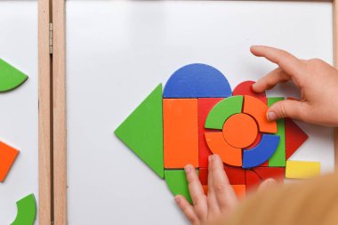 Çocuk renkli bulmaca oyuncaklarıyla oynuyor evde öğrenmek için şekiller yapıyor