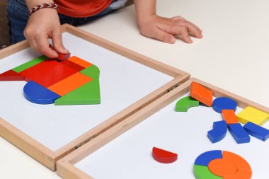 Çocuk renkli bulmaca oyuncaklarıyla oynuyor evde öğrenmek için şekiller yapıyor