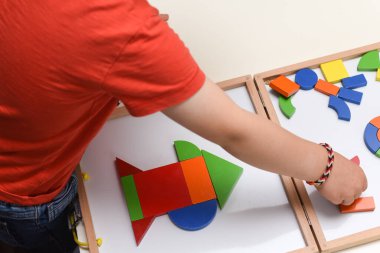 Çocuk renkli bulmaca oyuncaklarıyla oynuyor evde öğrenmek için şekiller yapıyor