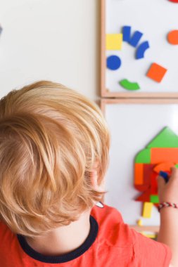 Çocuk renkli bulmaca oyuncaklarıyla oynuyor evde öğrenmek için şekiller yapıyor