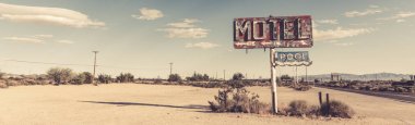 A dilapidated, vintage motel sign in the desert of Arizona clipart