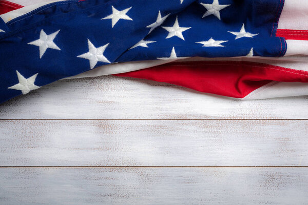 American flag on a white worn wooden background with copy space