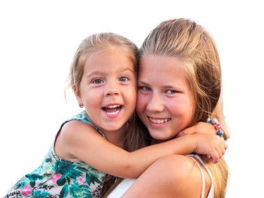 Sarılma ve kameraya bakarak iki kız kardeş eğlenceli. 