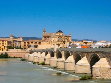 Cordoba 'da Guadalquivir Nehri 'nin karşısındaki antik katedral ve Roma Köprüsü manzarası