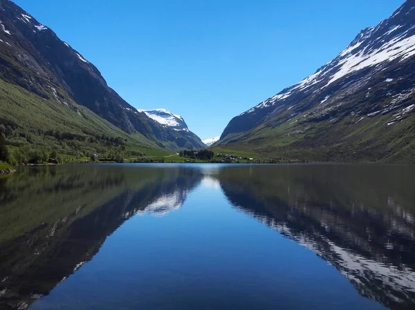 Picos de montaña reflejándose en el lago como en un espejo, Noruega — Foto de Stock