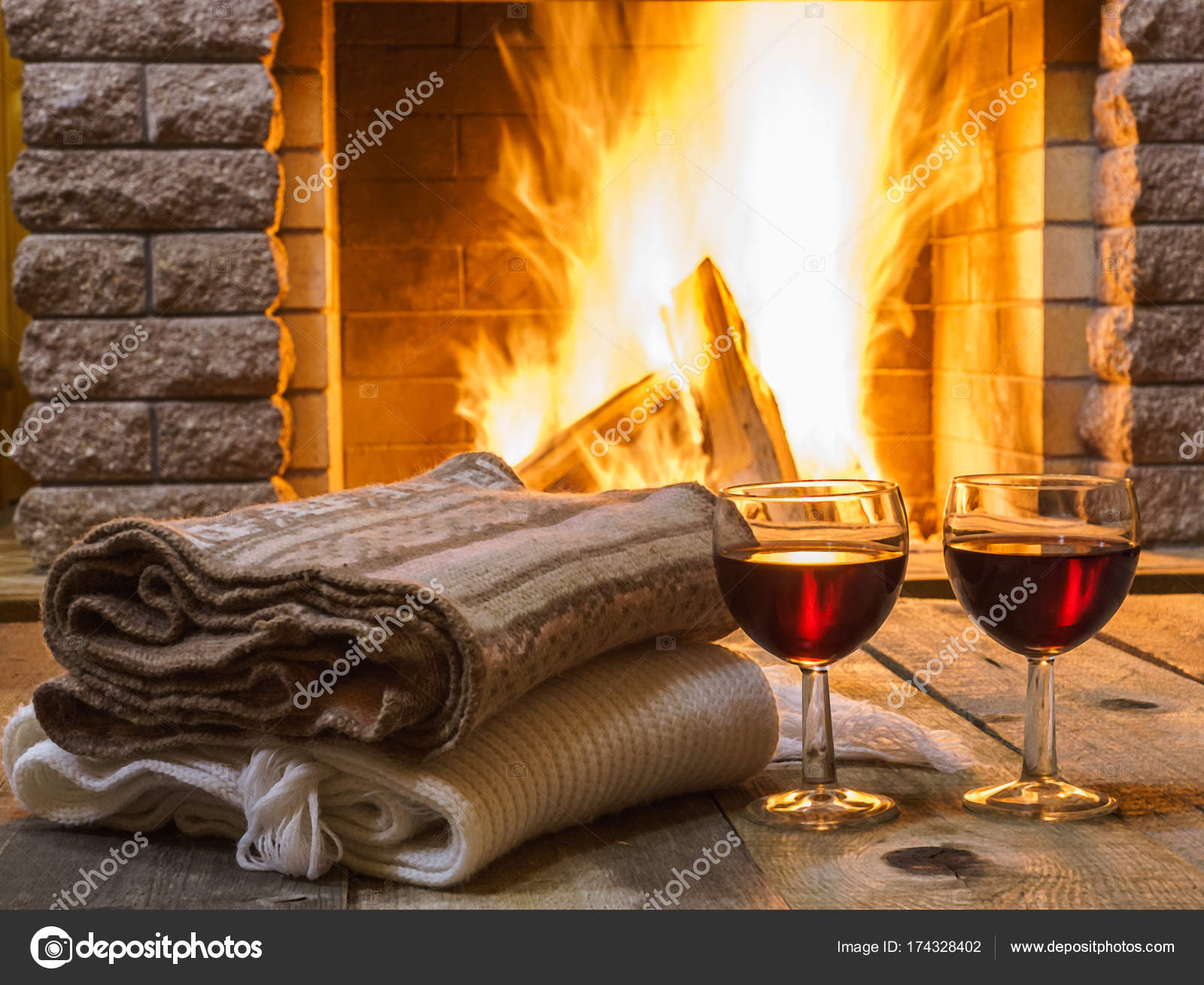 Zwei Gläser Rotwein; kuschelige Wollsachen, vor dem Kamin, im Landhaus