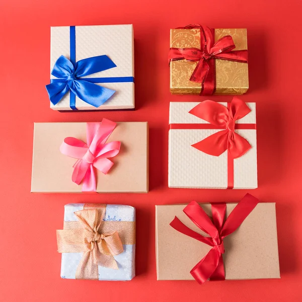 Set of festive Christmas gift boxes on red background.