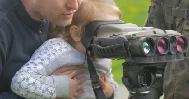 ポーランド オポール 2016年5月02日 デバイスを見ている少女を抱えている男 リトルガールへの軍事装備のデモ 父親は小さな娘の軍事楽器を示しています — ストック動画