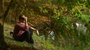 Video 360 derece izlerken 360vr gözlük güneşli gün Park su ile sanal oyunlar oynarken koyar sonra su almak kulaklık kaldırır adam