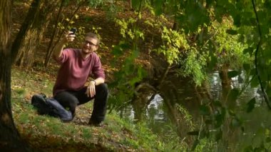 Dostum yapar Video çağrısı Video 360 derece izlerken 360vr gözlük sanal oyunlar oynarken güneşli gün Park su alır kulaklık ile sırt çantası koyar