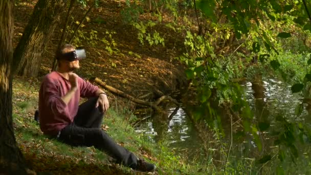 ビデオ 360 度湖して晴れた日の公園で仮想ゲーム頭を回して本当の感じているを見て 360 vr サンレミバスティオン眼鏡の男は、ヘッドセットを削除します — ストック動画